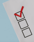 Checklist with red checkmark representing simplified Corporate Transparency Act (CTA) reporting requirements for small businesses under new FinCEN interim rule
